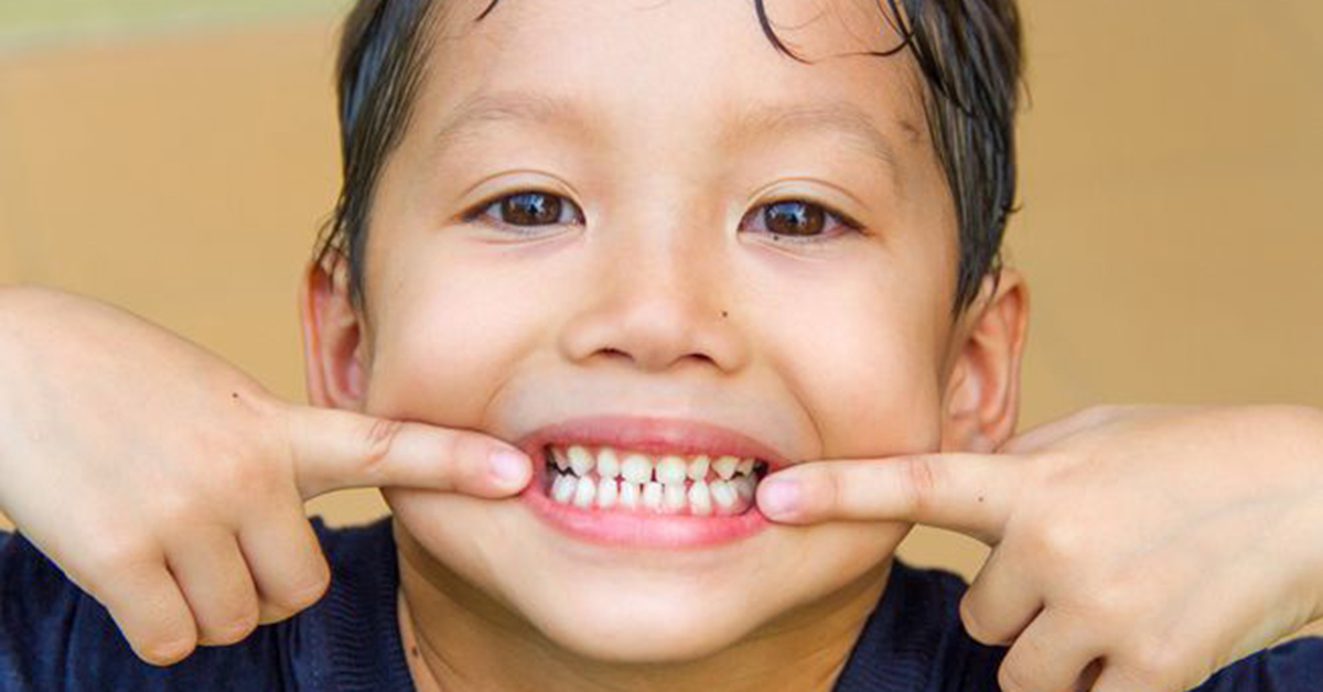 A boy shows his teeth